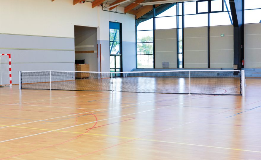 Ovoid tennis post installed in a gymnasium