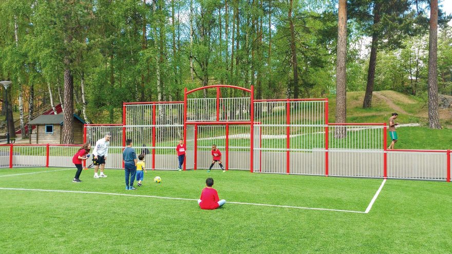 terrain multisport Metalu Plast Deauville rouge avec enfant qui jouent au football